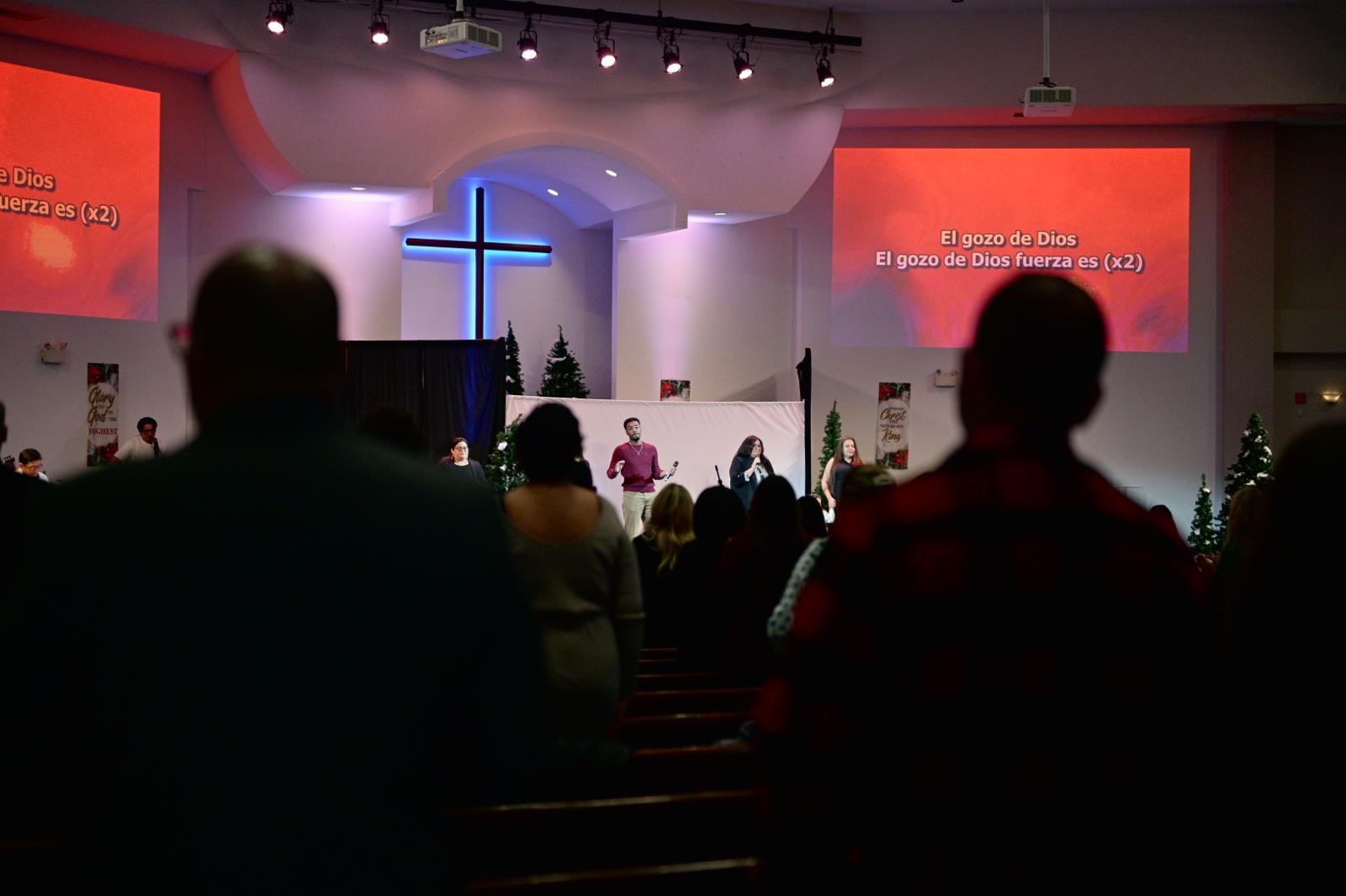 Worship service with congregation and illuminated cross